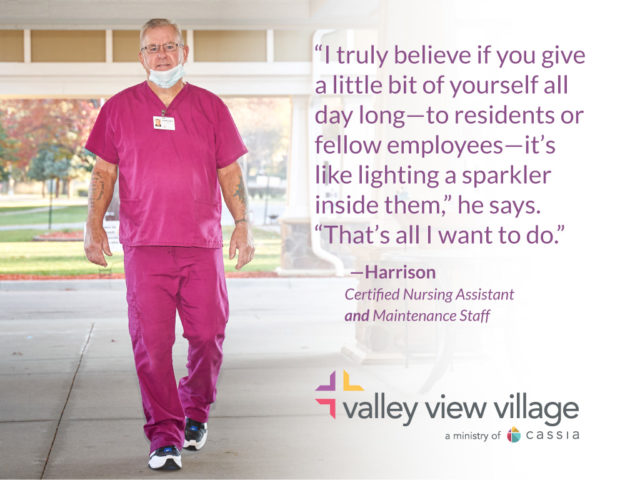 Harrison in pink scrubs, walking toward the camera